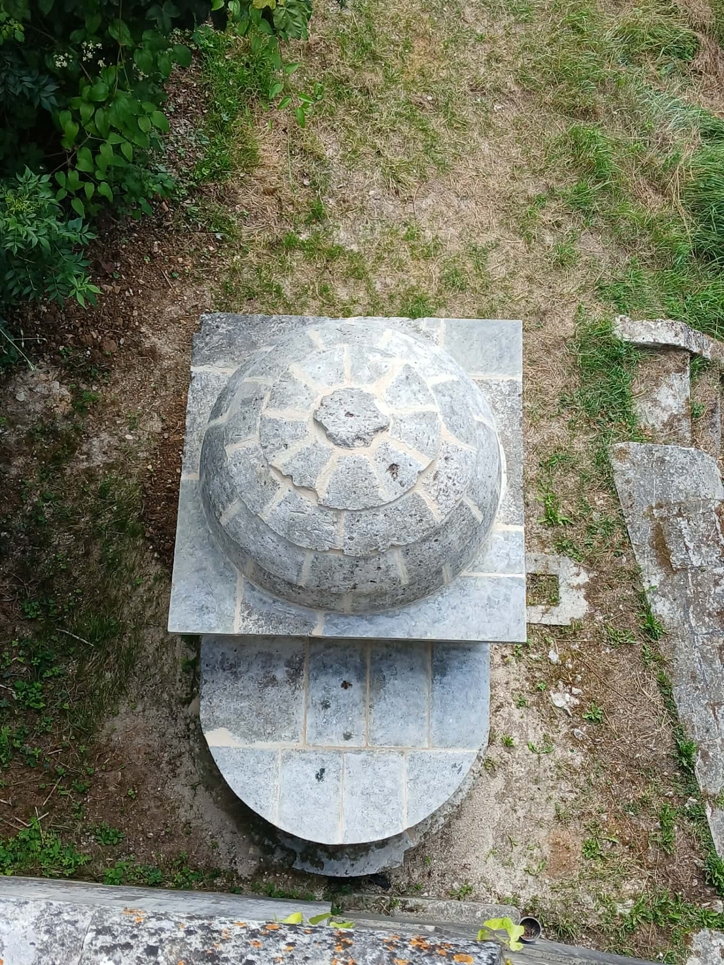 Vue plongeante sur le dôme en écailles de pierre et la margelle