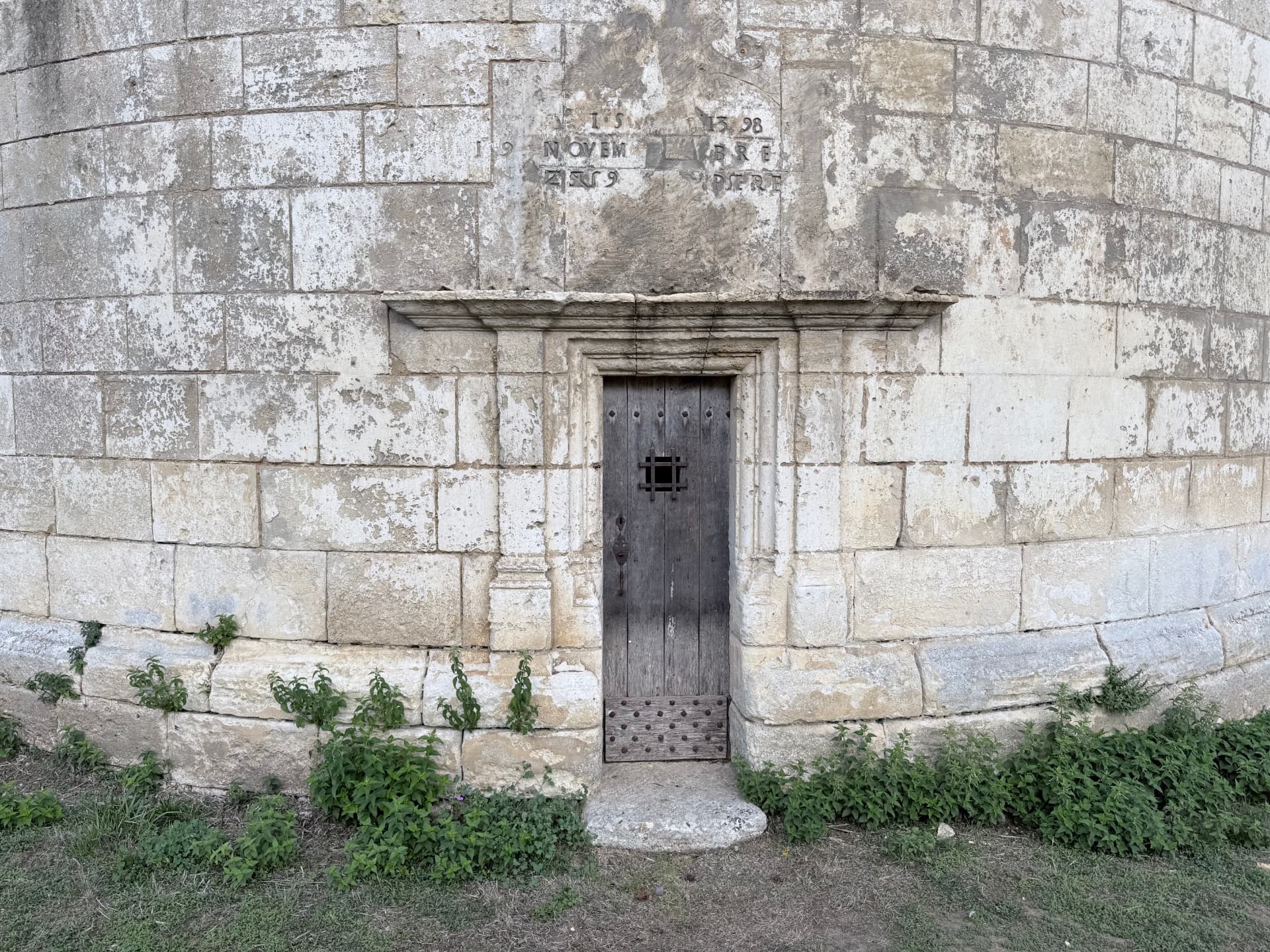 Porte en bois cloutée du pigeonnier de Moustierneuf, surmontée d'une inscription gravée datée de 1598