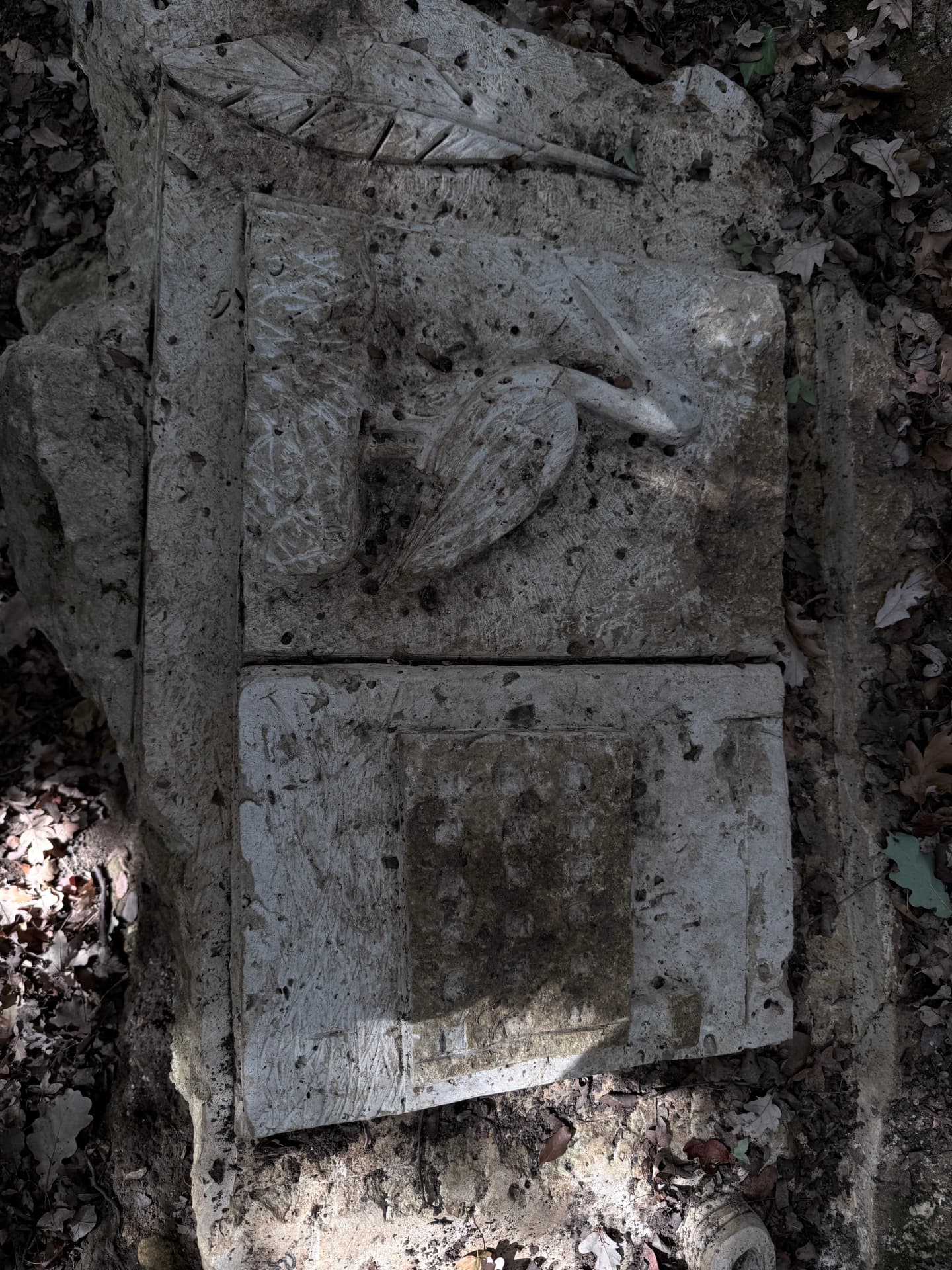 Livre de pierre ouvert sculpté d'un héron et d'un damier