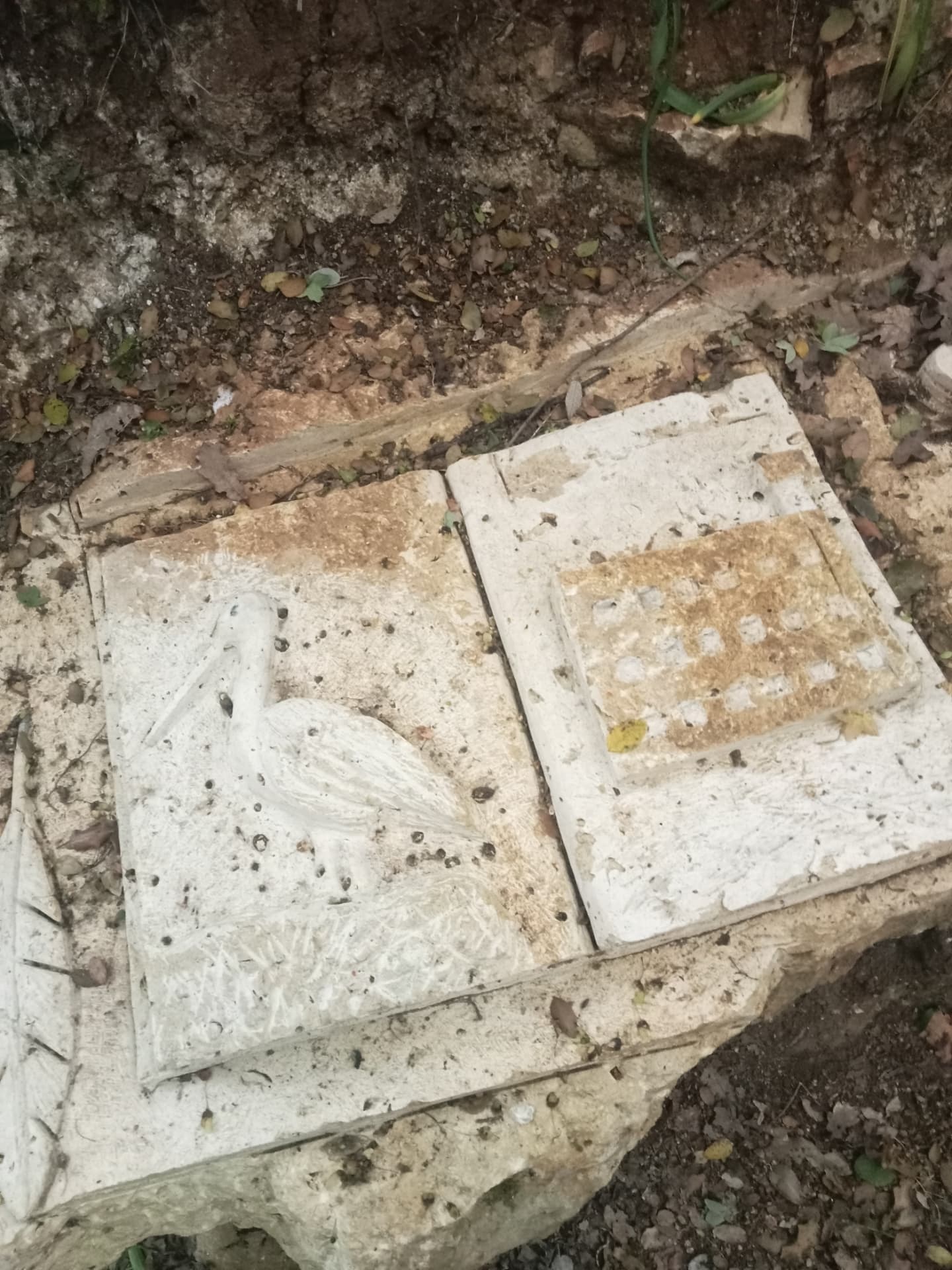 Livre de pierre ouvert sculpté d'un héron et d'un damier