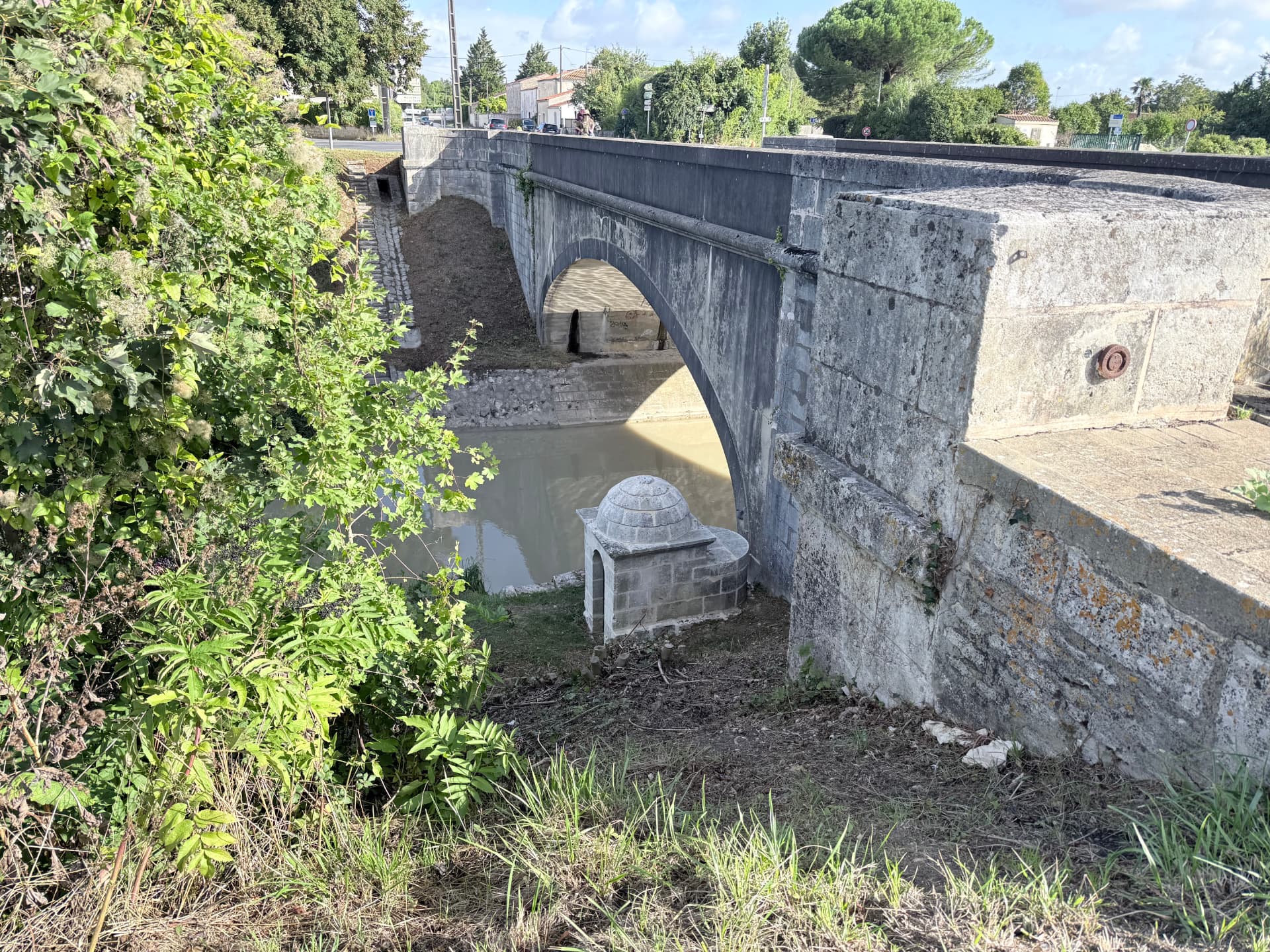 La fontaine Charles coiffée de son dôme de pierre, au pied du pont du canal de la Bridoire