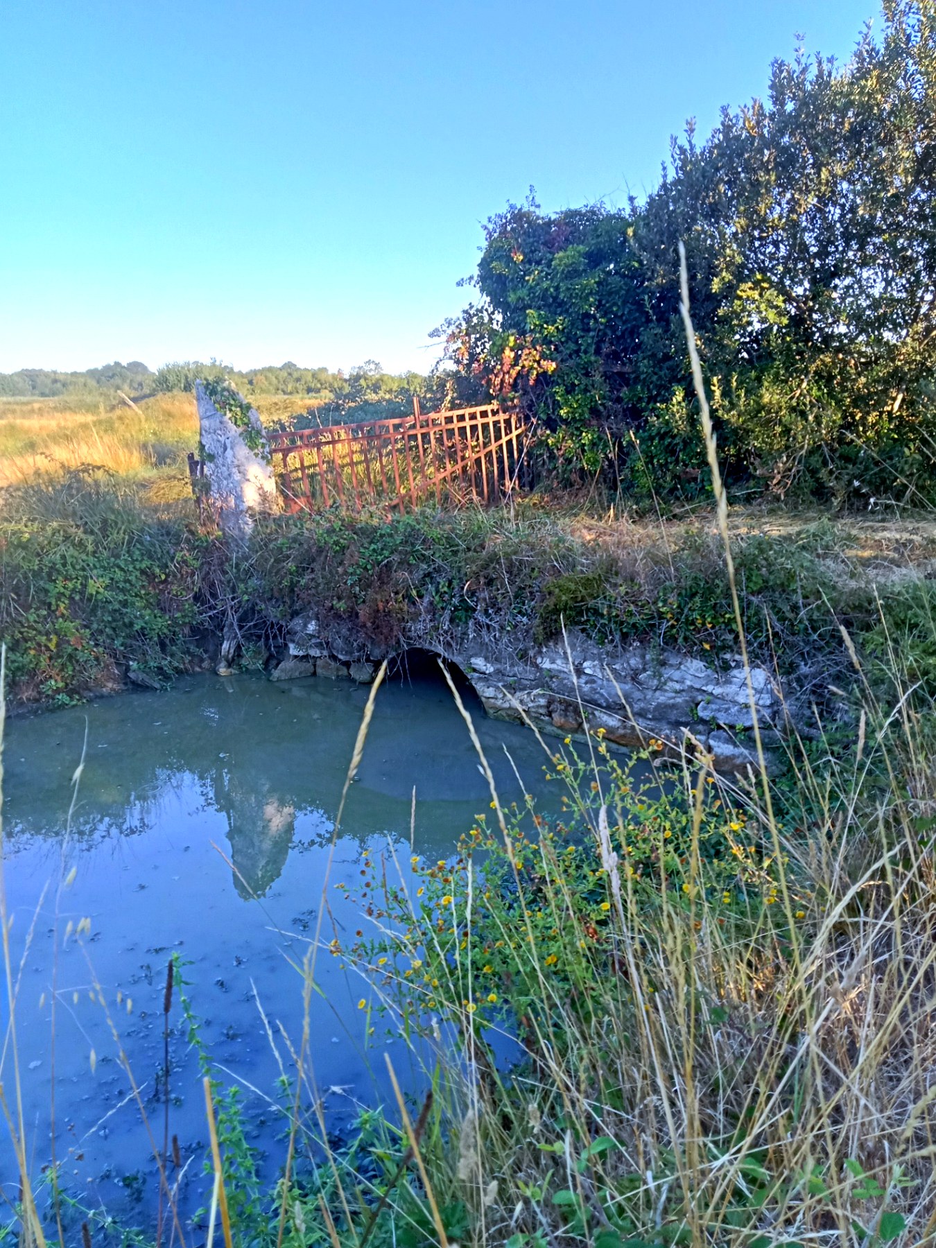 Vanne de pierre et passerelle au-dessus d'un canal