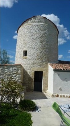 Tour de pierre du moulin de Saint-Agnant restaurée sous un ciel bleu