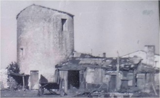 Photographie ancienne d'un moulin en ruine avec ses dépendances