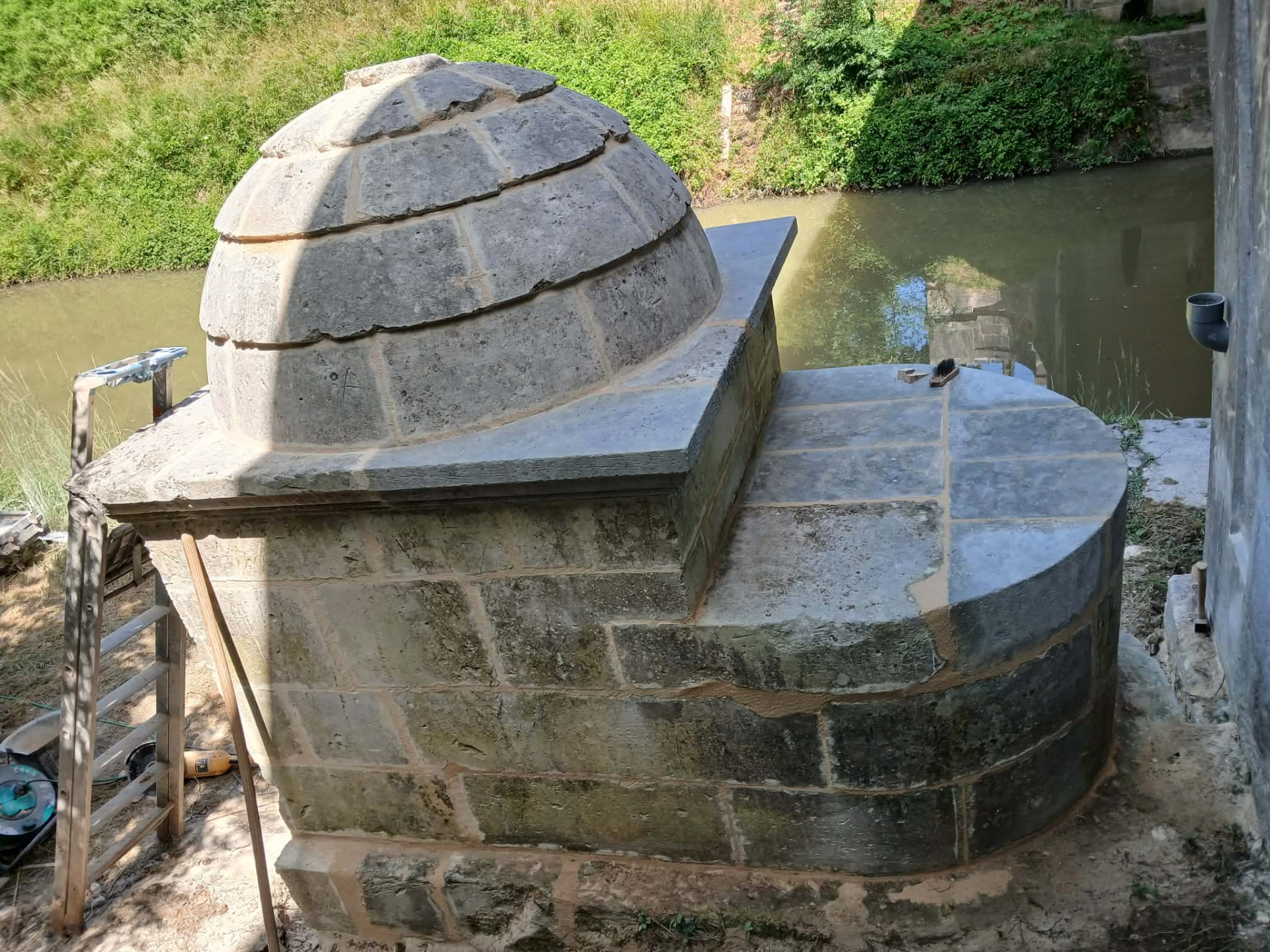 Le dôme de pierre et la margelle du puits vus depuis le pont